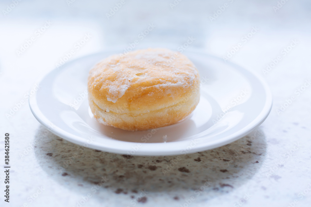 Delicious sugar donut on a white plate Delicious sugar donut on a white plate