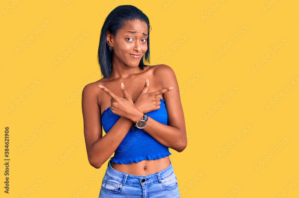 Young african american woman wearing casual summer clothes pointing to both sides with fingers, different direction disagree Young african american woman wearing casual summer clothes pointing to both sides with fingers, different direction disagree