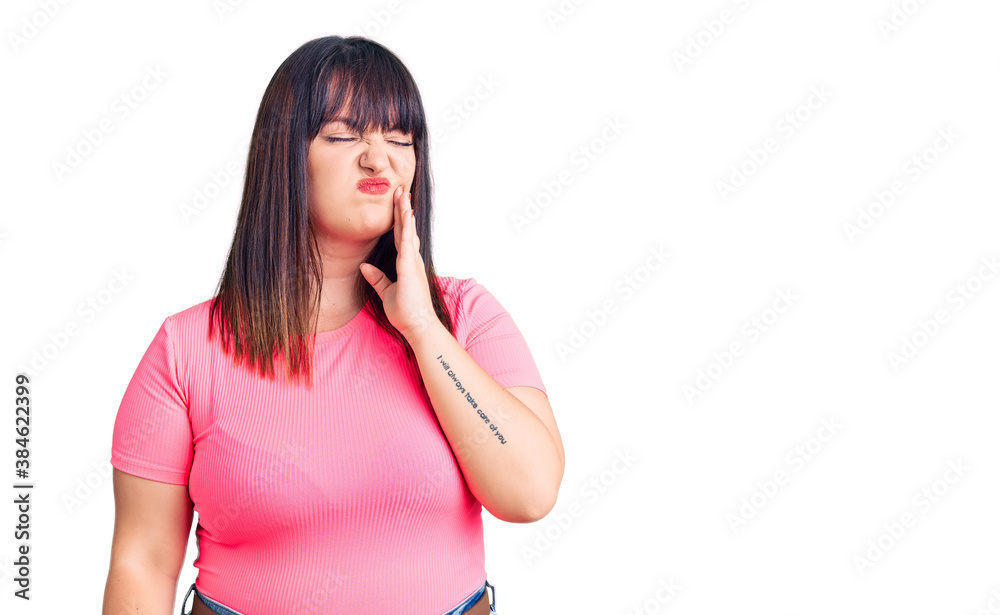 Young plus size woman wearing casual clothes touching mouth with hand with painful expression because of toothache or dental illness on teeth. dentist Young plus size woman wearing casual clothes touching mouth with hand with painful expression because of toothache or dental illness on teeth. dentist