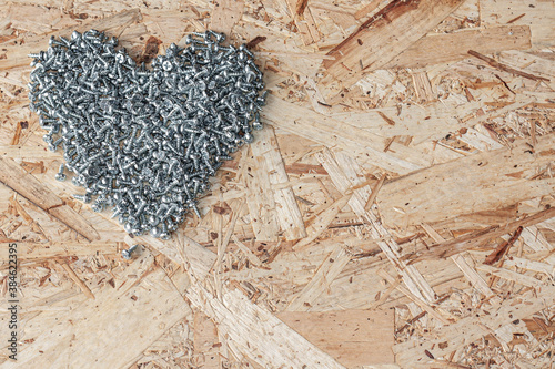 Valentine's day for builders, heart made of screws on wooden background, strong heart, strong love, i love u, love you