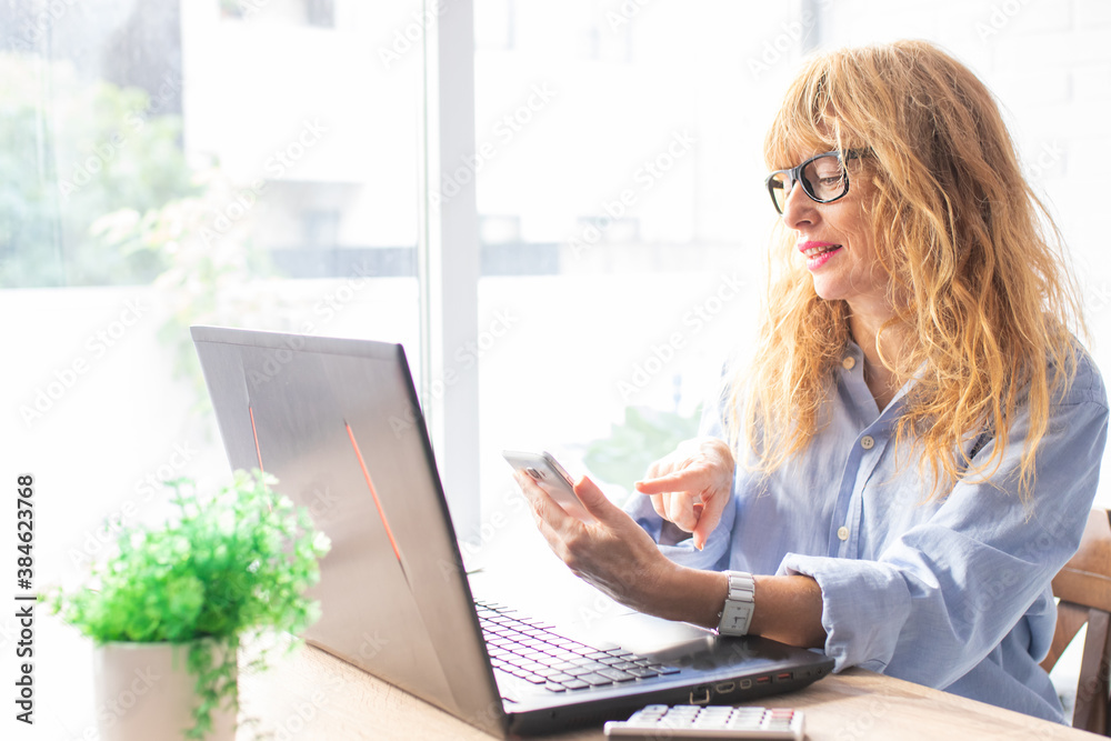 adult attractive woman with mobile phone and computer in office or home adult attractive woman with mobile phone and computer in office or home