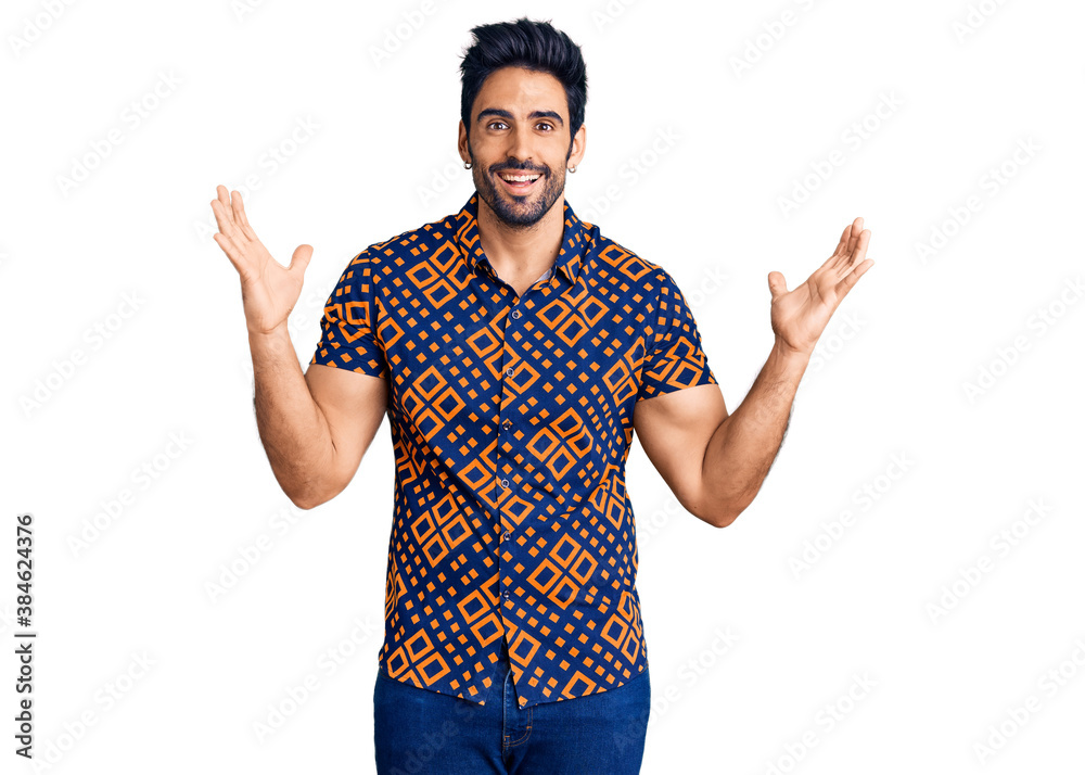 Handsome hispanic man wearing casual clothes celebrating victory with happy smile and winner expression with raised hands Handsome hispanic man wearing casual clothes celebrating victory with happy smile and winner expression with raised hands