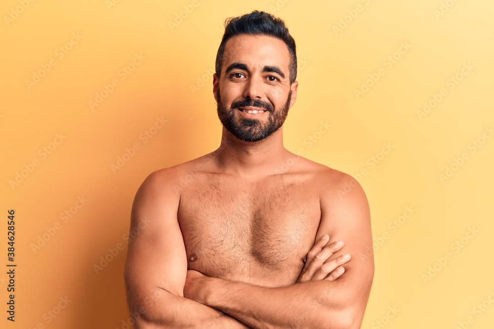 Young hispanic man standing shirtless happy face smiling with crossed arms looking at the camera. positive person.