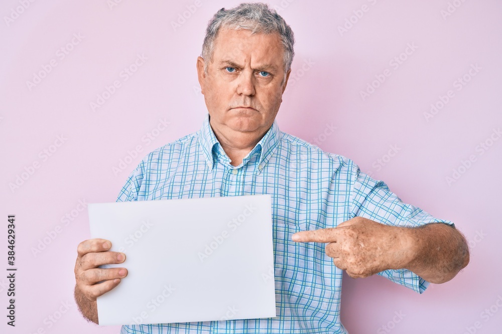 Senior grey-haired man holding blank empty banner skeptic and nervous, frowning upset because of problem. negative person. Senior grey-haired man holding blank empty banner skeptic and nervous, frowning upset because of problem. negative person.