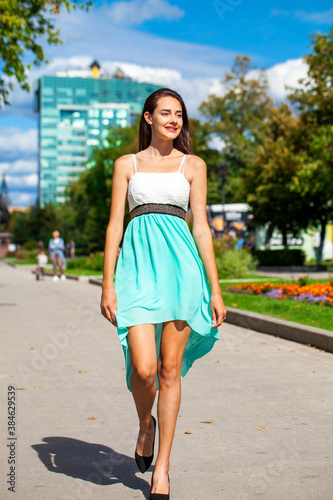 Young beautiful brunette woman in a turquoise dress