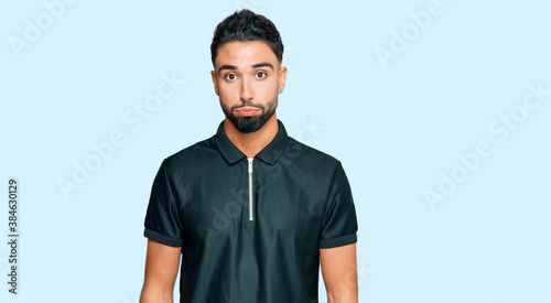 Young man with beard wearing sportswear puffing cheeks with funny face. mouth inflated with air, crazy expression.