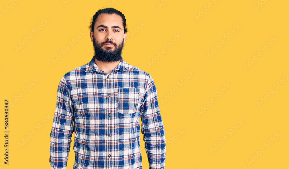 Young arab man wearing casual clothes relaxed with serious expression on face. simple and natural looking at the camera. Young arab man wearing casual clothes relaxed with serious expression on face. simple and natural looking at the camera.
