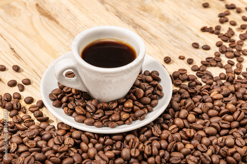 Cup of Espresso Coffee and roasted beans on wooden table background