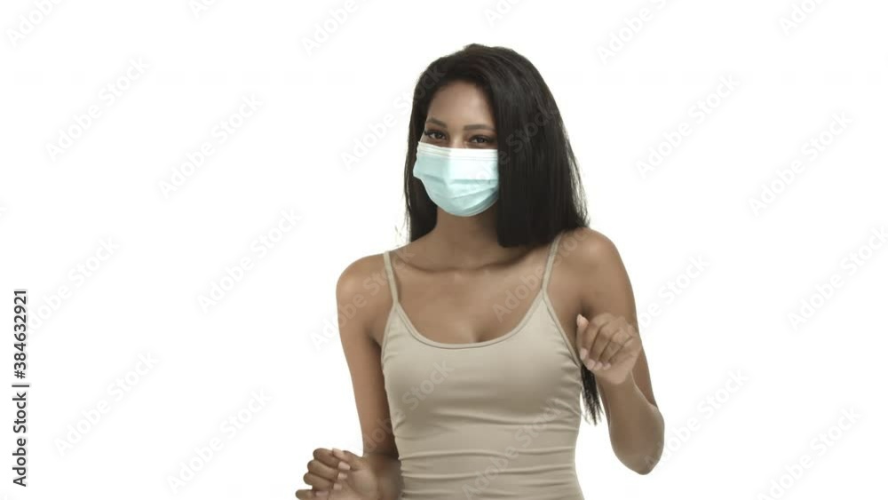 Quarantine, coronavirus and social distancing concept. Beautiful african-american woman in casual tank-top and medical mask, dancing over white background