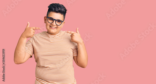 Obraz na plátně Little boy kid wearing casual clothes and glasses smiling cheerful showing and pointing with fingers teeth and mouth