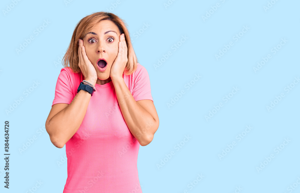 Young blonde woman wearing sportswear afraid and shocked, surprise and amazed expression with hands on face Young blonde woman wearing sportswear afraid and shocked, surprise and amazed expression with hands on face