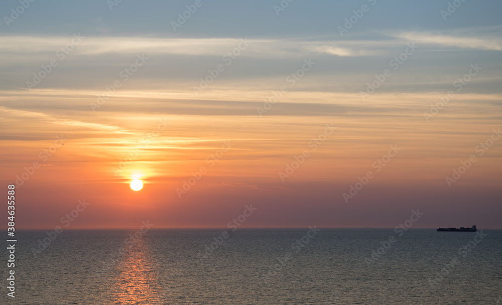 Naklejka premium Sunset in the sea on a warm summer evening, seascape.