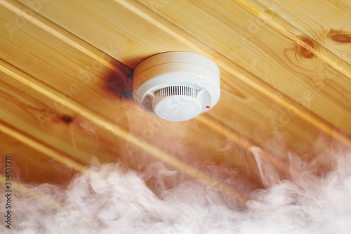 Obraz na płótnie smoke detector in wooden house, fire alarm in action