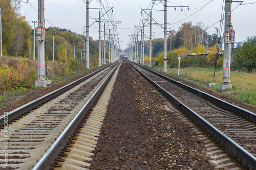 Railway track with electricity pylons in perspective view go into the horizon