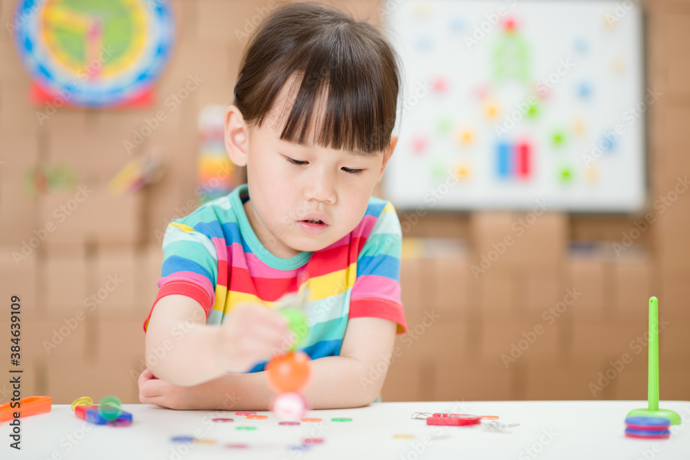 Fototapeta premium young girl play magical magnet experiments at home for homeschooling