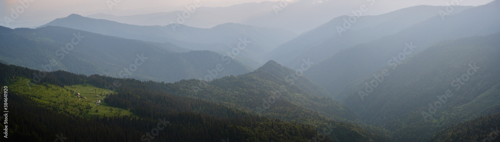 Summer misty evening mountain tops silhouettes. Marmaros, Carpathians, Ukraine.