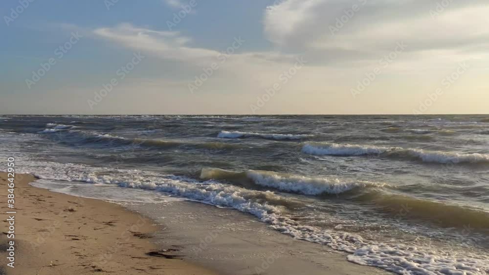 Sun goes down in sea, golden color sky with stormy white waves on sea shore sand beach. Left to right panoramic move. Magic sunset vacation romantic evening Sun goes down in sea, golden color sky with stormy white waves on sea shore sand beach. Left to right panoramic move. Magic sunset vacation romantic evening