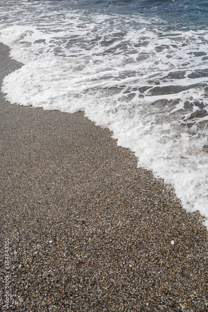 Sea water from a wave with foam on the seashore Sea water from a wave with foam on the seashore