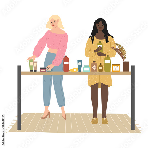 Blonde and black girls choosing bodycare and home products in cosmetics store