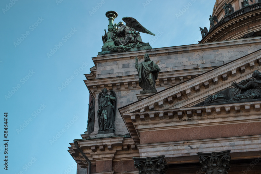 Isaac's Cathedral, Saint Petersburg, Russia, 11.10.2020. Historic building is in style of classicism. Facade, exterior with green sculptures, green angels statues. Blue sky