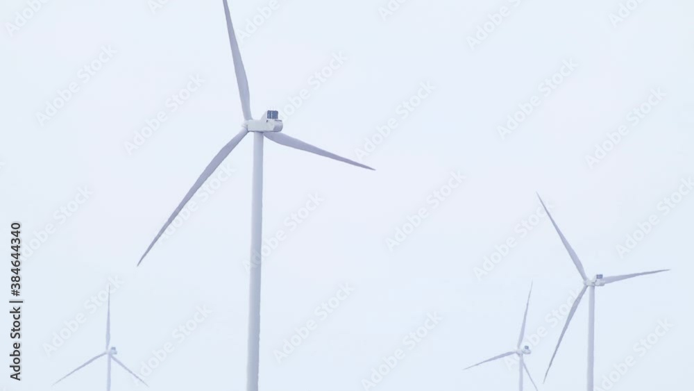 Wind electro generators farm close-up rotating on grey sky loop footage. Green eco energy of future in countryside. Ukraine turbines, power generation Wind electro generators farm close-up rotating on grey sky loop footage. Green eco energy of future in countryside. Ukraine turbines, power generation