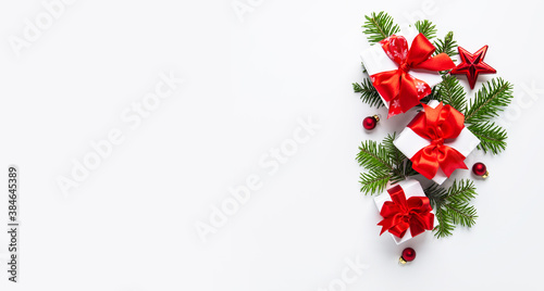 Merry Christmas and Happy Holidays greeting card, frame, banner. New Year. Noel. Red Christmas ornaments and gift on white background top view. Winter xmas holiday theme. Flat lay 