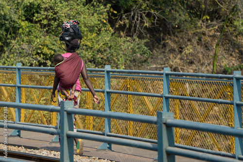 Woman with baby crossing thee bridge between ZAMBIA and ZIMBABWE photo