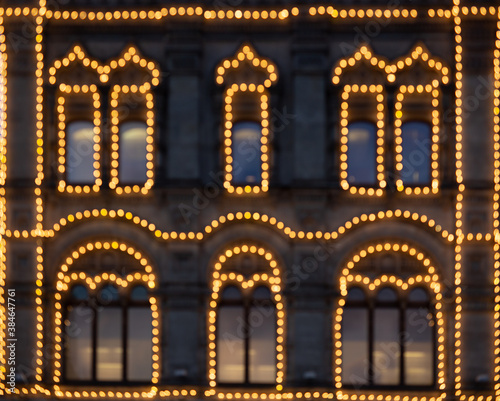 Defocused image of light decor decorating the exterior facade and windows of one of Moscow's historic houses. The image is symmetrical and axially symmetrical. photo