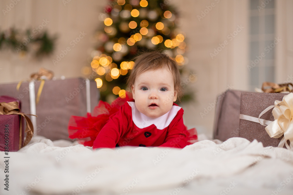 Portrait of happy little girl in red knitted sweater with Christmas present box near Christmas tree. Happy childhood. Waiting for a Christmas tale Portrait of happy little girl in red knitted sweater with Christmas present box near Christmas tree. Happy childhood. Waiting for a Christmas tale