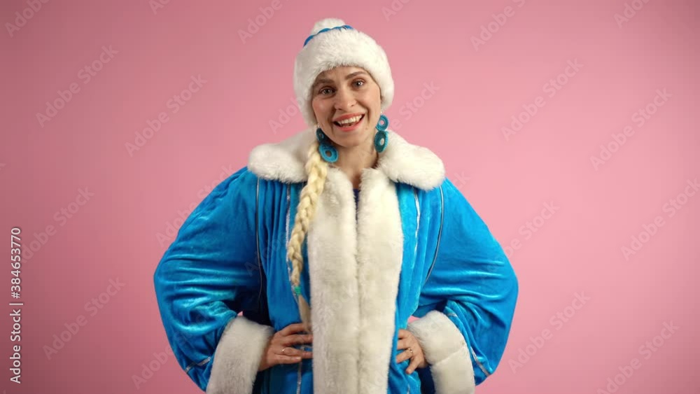 Dancing Snow Maiden on pink background, smiling woman in blue christmas costume looking on camera, gesturing with hands and dancing slowly. Christmas traditional dancing of santa woman, xmas holidays Dancing Snow Maiden on pink background, smiling woman in blue christmas costume looking on camera, gesturing with hands and dancing slowly. Christmas traditional dancing of santa woman, xmas holidays