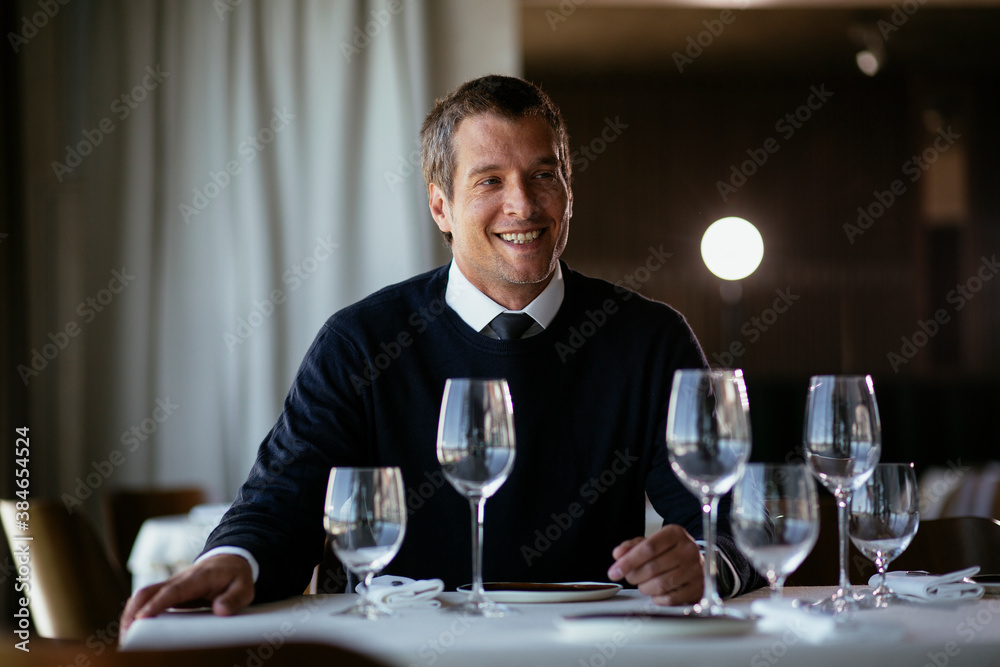 Handsome businessman dressed in the suit drinking wine. Businessman enjoying in the restaurant