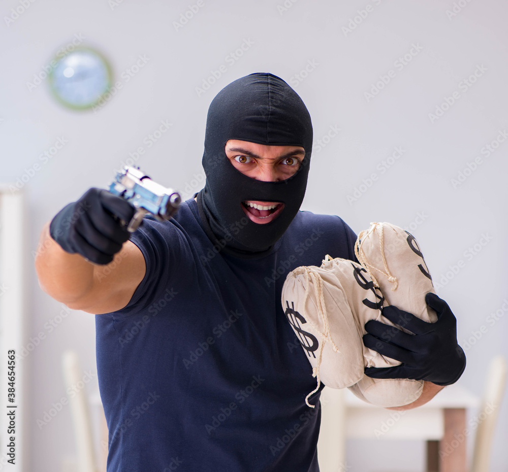 Robber wearing balaclava stealing valuable things Robber wearing balaclava stealing valuable things