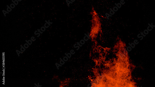 CLOSE UP: Fiery orange flames flicker high into the pitch black night sky.