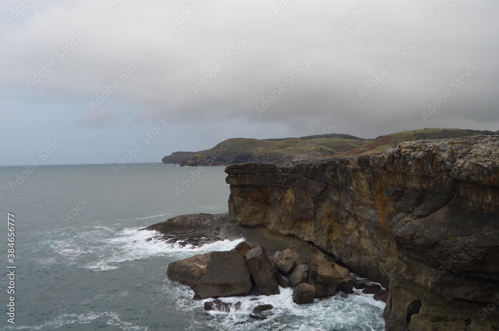 Obraz premium Rocky cliffs crumbled by strong waves