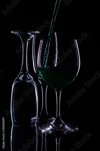  set of glasses with black background and serving green liquid