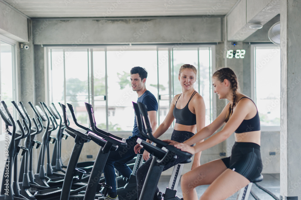 Obraz premium female athletes talk about exercise, cycling in the gym. They wear sportswear to exercise.