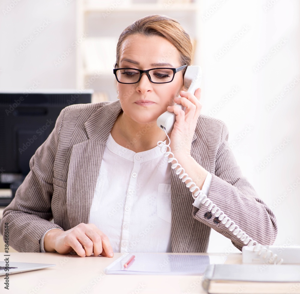 Businesswoman employee talking on the office phone Businesswoman employee talking on the office phone
