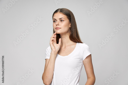 The woman in a white T-shirt looks to the side attractive look long hair © SHOTPRIME STUDIO