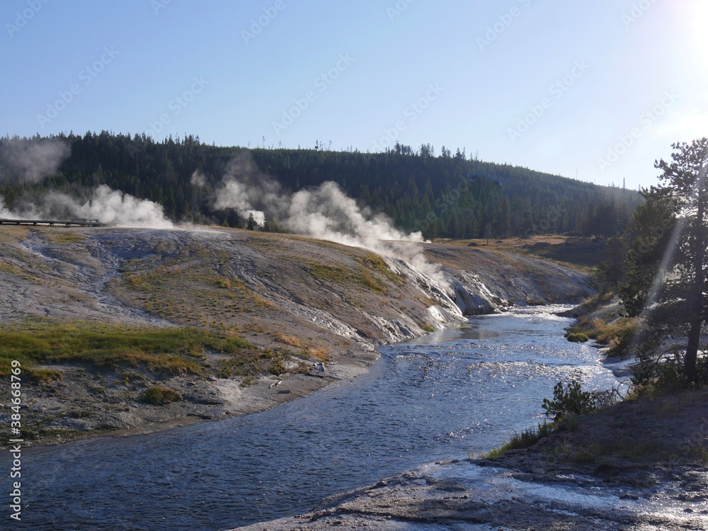 Geysers release hot steam as boiling water flows into the stream at the Upper Geyser Basin at Yellowstone National Park.