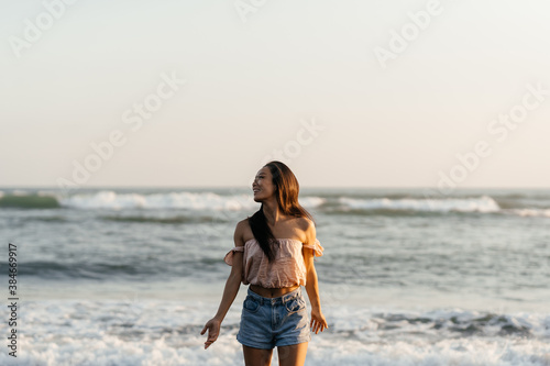 Smile Freedom and happiness chinese woman on beach. She is enjoying serene ocean nature during travel holidays vacation outdoors. asian beauty. summer time