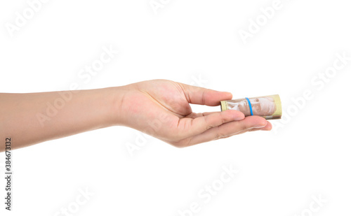 A hand holding a Canadian dollar bill in front of a white background makes a gesture of giving