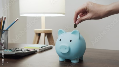 Young woman put coins in a piggy bank with saving money is investment for the future. Calculate income and expenses in daily life. photo