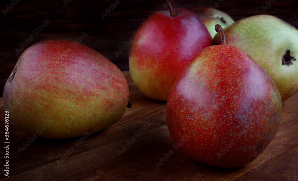 Several ripe pears lie on a wooden board. Several ripe pears lie on a wooden board.