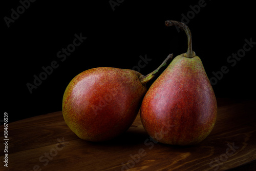 Two beautiful ripe pears on a wooden table.