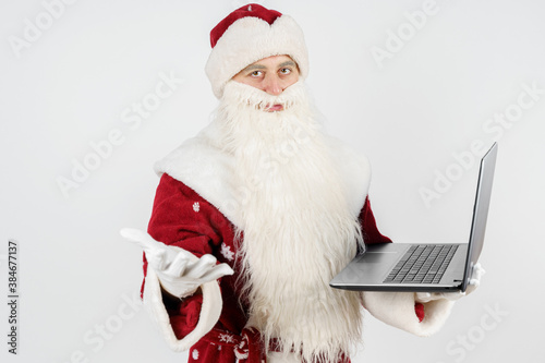 Santa Claus sits at his desk and works at the computer.