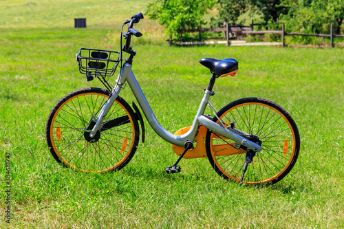 Modern bicycle parked on a green lawn in rural area