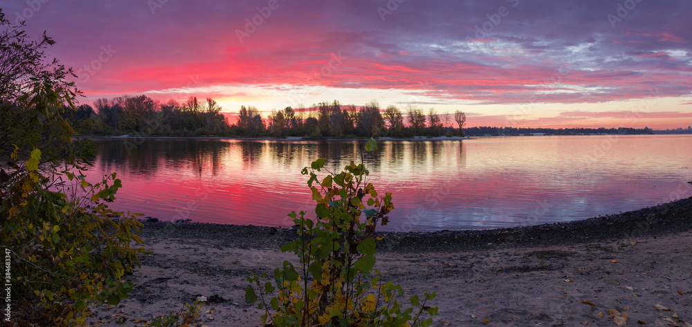 Panorama of wide river with forested banks autumn before sunrise