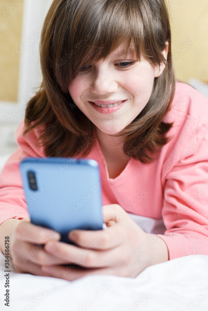 girl on bed with phone in her hands girl on bed with phone in her hands