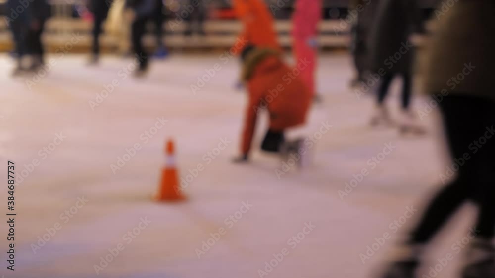 Defocus. Men women children skate on ice in winter. People doing amateur sports. New Year Christmas festive atmosphere Defocus. Men women children skate on ice in winter. People doing amateur sports. New Year Christmas festive atmosphere