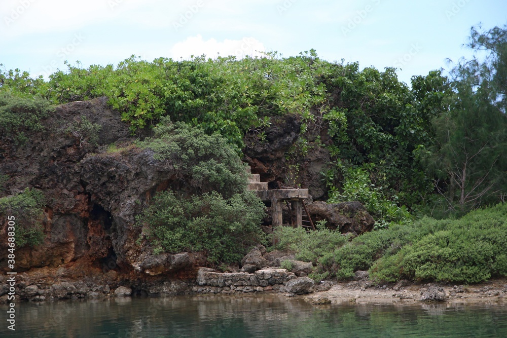 Clear waters of Inarajan Bay with a rocky cliff and green vegetation on Guam Clear waters of Inarajan Bay with a rocky cliff and green vegetation on Guam
